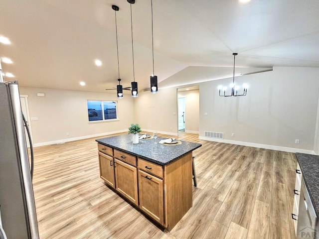 kitchen featuring visible vents, light wood-style flooring, open floor plan, freestanding refrigerator, and vaulted ceiling