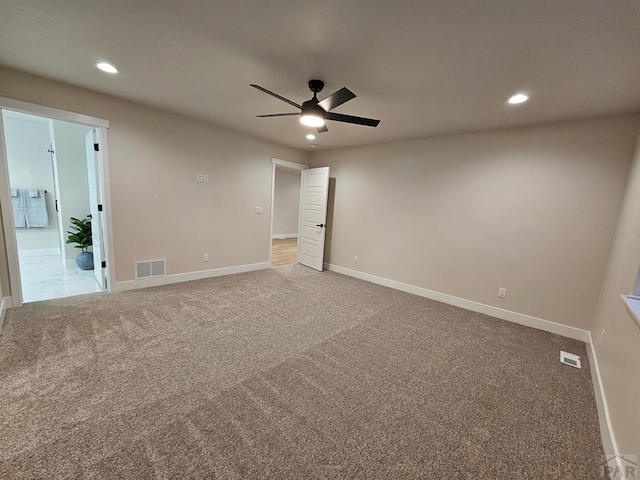 empty room featuring visible vents, light colored carpet, and baseboards