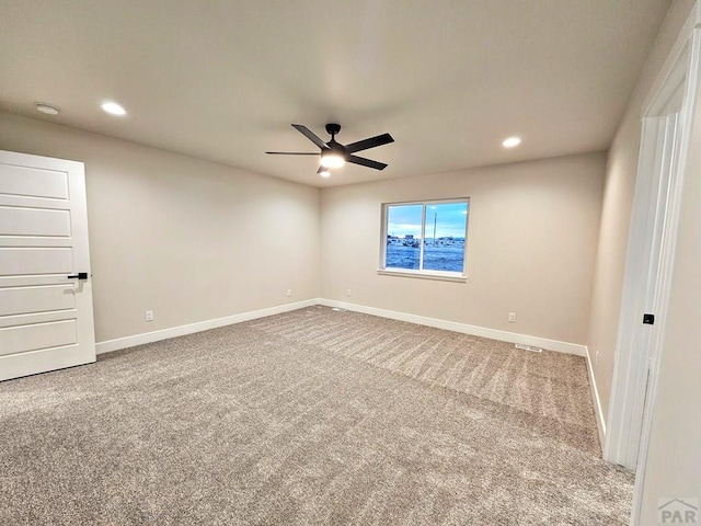 carpeted spare room featuring recessed lighting, a ceiling fan, and baseboards