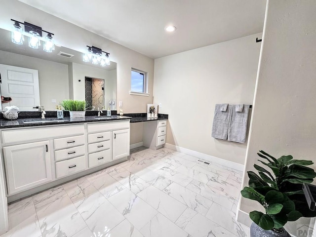 bathroom with baseboards, marble finish floor, and a sink