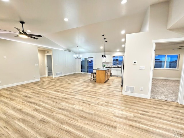 kitchen featuring open floor plan, ceiling fan with notable chandelier, and visible vents