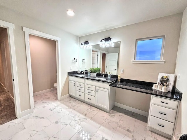 bathroom featuring a sink, baseboards, and marble finish floor