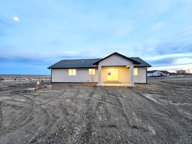 back of property featuring roof with shingles and stucco siding