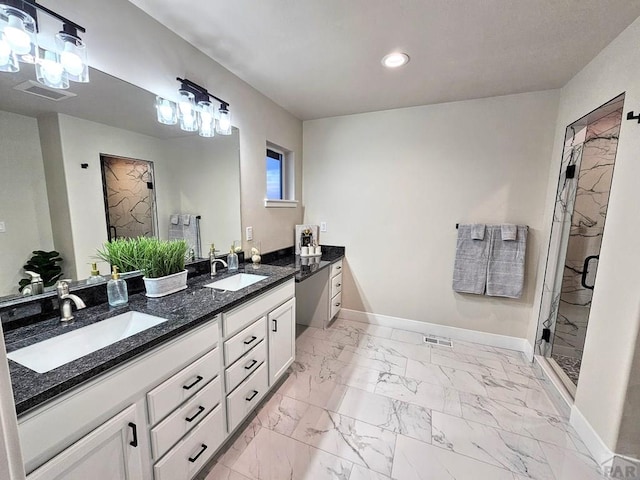 full bathroom with marble finish floor, a shower stall, baseboards, and a sink