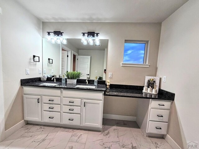 bathroom with double vanity, marble finish floor, baseboards, and a sink