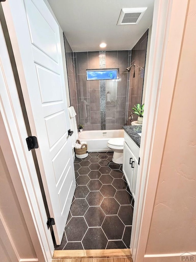 bathroom with tile patterned flooring, visible vents, toilet, shower / bathing tub combination, and vanity