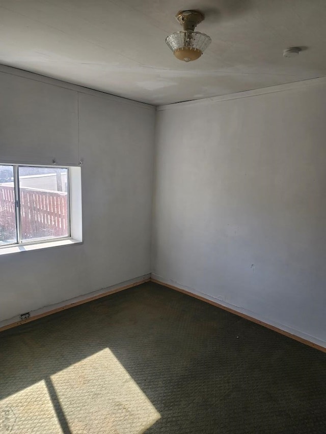 unfurnished room featuring dark carpet