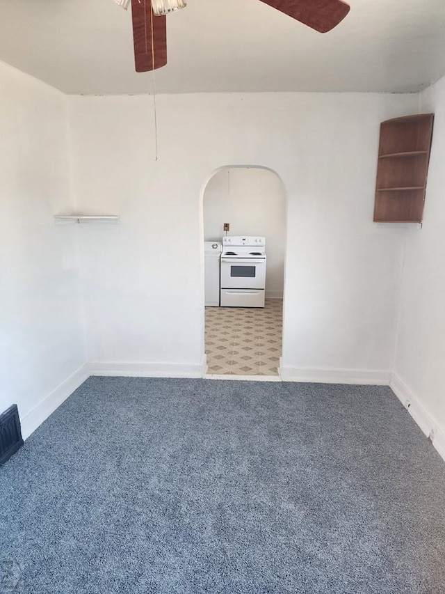 empty room featuring carpet, ceiling fan, arched walkways, and baseboards