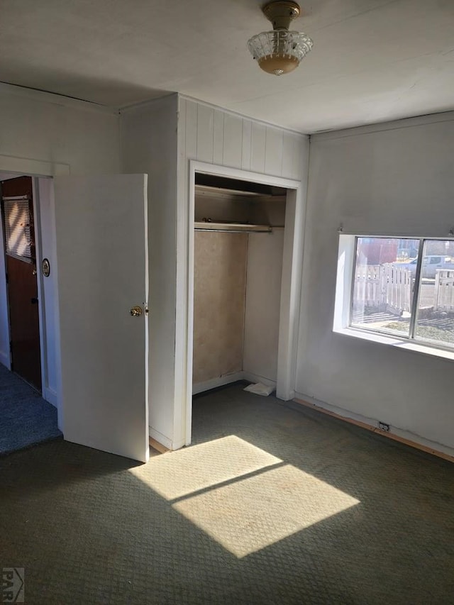 unfurnished bedroom with a closet and dark carpet