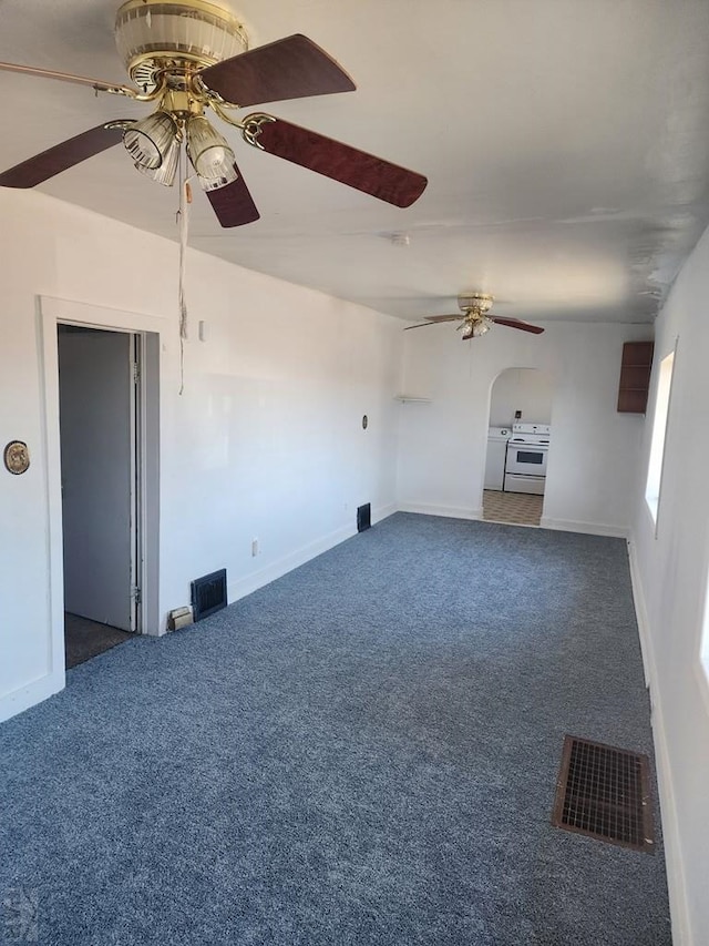 unfurnished room featuring baseboards, visible vents, dark colored carpet, and a ceiling fan