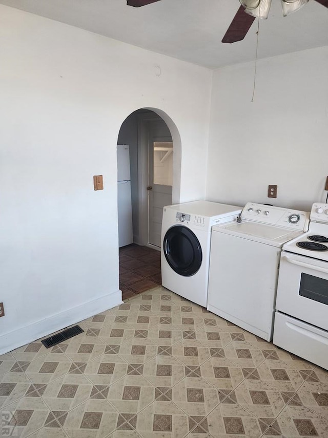 laundry area with arched walkways, visible vents, baseboards, washer and dryer, and a ceiling fan