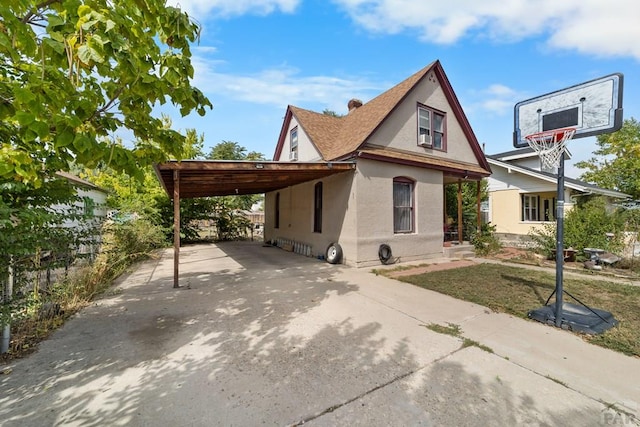 view of front of house with a carport, driveway, and stucco siding