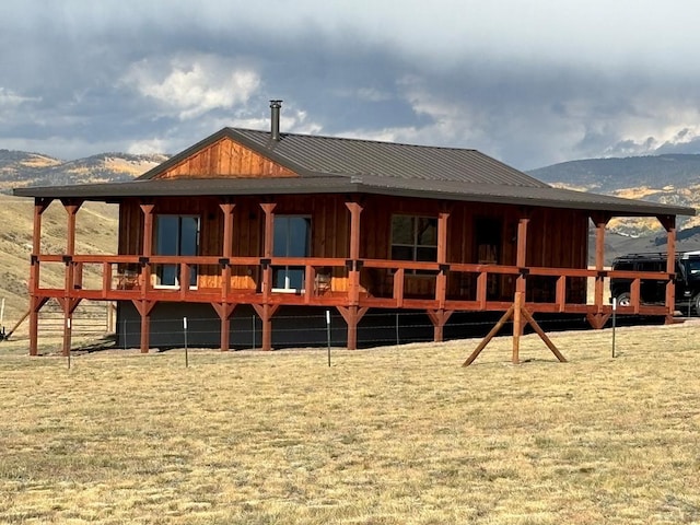 rear view of house featuring a mountain view, metal roof, and board and batten siding