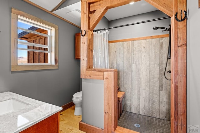 full bathroom with toilet, a stall shower, wood finished floors, and vanity