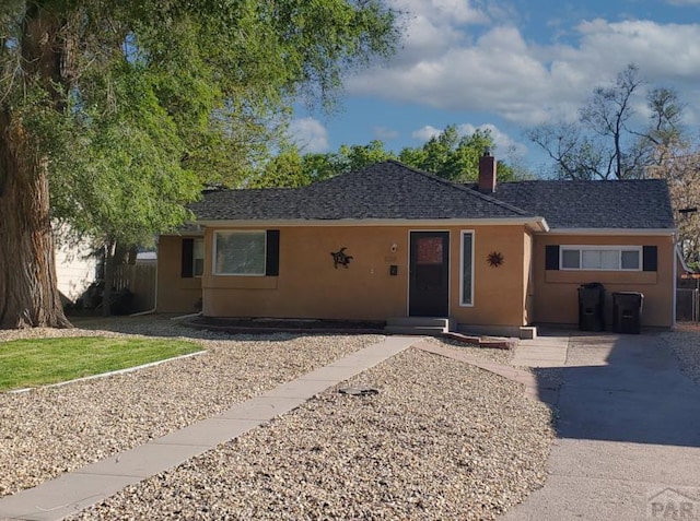 924 W Routt Ave, Pueblo, CO 81004 - single story home with stucco siding, roof with shingles, and a chimney