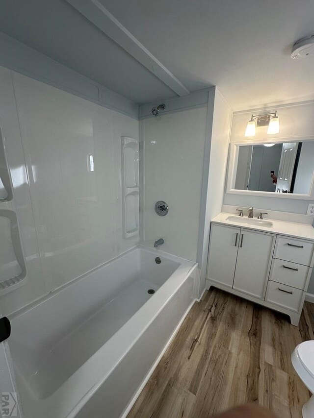 bathroom with  shower combination, vanity, wood finished floors, and toilet