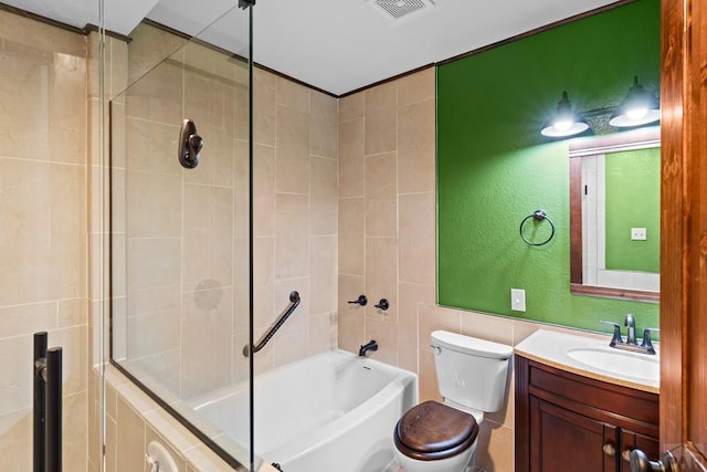 full bath with tiled shower / bath, visible vents, a textured wall, toilet, and vanity