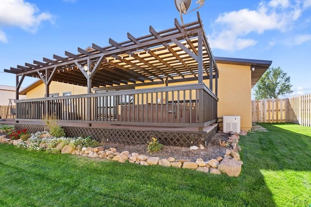 rear view of property featuring a yard, stucco siding, fence, a pergola, and a wooden deck