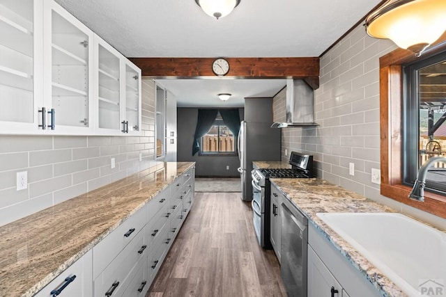 kitchen featuring stainless steel appliances, a sink, glass insert cabinets, and white cabinets