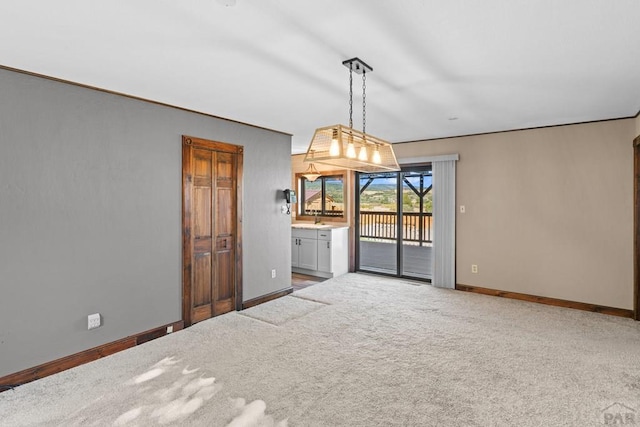 empty room with carpet, baseboards, and a sink