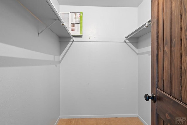 walk in closet with light wood-type flooring