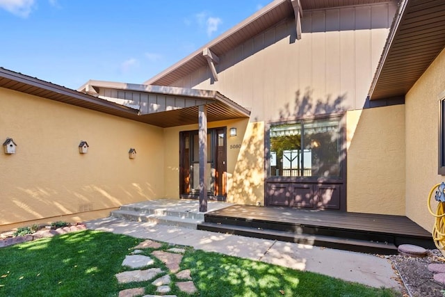 property entrance with a deck and stucco siding