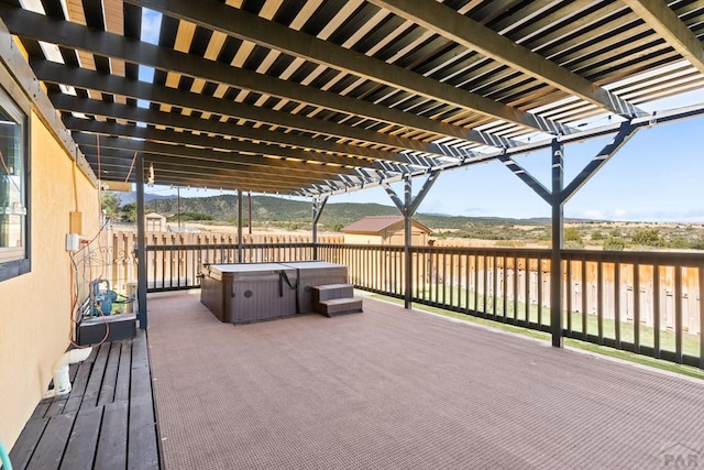 deck with fence, a hot tub, and a pergola