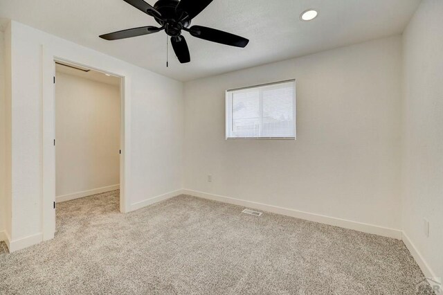 unfurnished room with baseboards, a ceiling fan, carpet, and visible vents