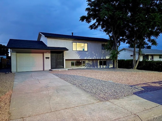 3923 Lancaster Dr, Pueblo, CO 81005 - tri-level home with concrete driveway, a garage, and stucco siding