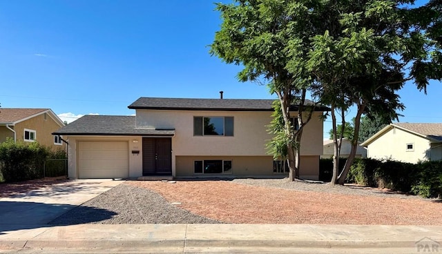 3923 Lancaster Dr, Pueblo, CO 81005 - split level home with driveway, an attached garage, and stucco siding