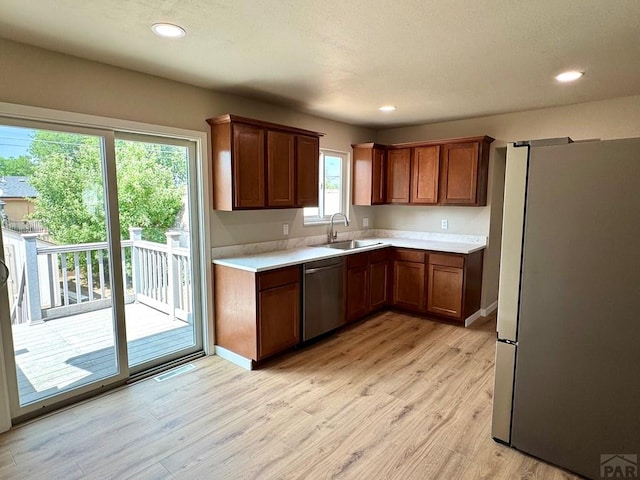 3923 Lancaster Dr, Pueblo, CO 81005 - kitchen with appliances with stainless steel finishes, light countertops, light wood-style flooring, brown cabinets, and recessed lighting