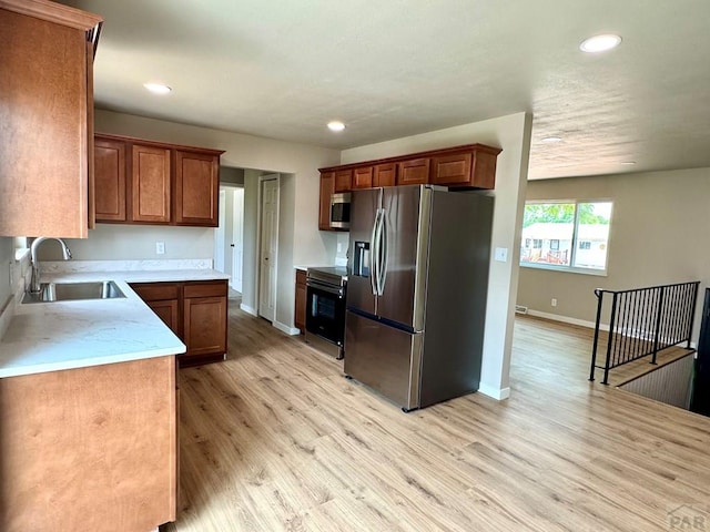 3923 Lancaster Dr, Pueblo, CO 81005 - kitchen with stainless steel appliances, recessed lighting, light wood-type flooring, light countertops, and brown cabinetry
