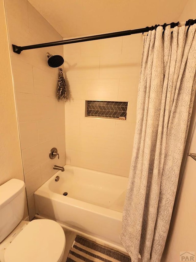 bathroom with shower / bath combination with curtain and toilet