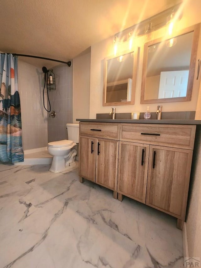 full bathroom with marble finish floor, double vanity, toilet, a stall shower, and a textured ceiling