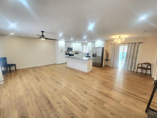 kitchen with open floor plan, appliances with stainless steel finishes, and white cabinetry