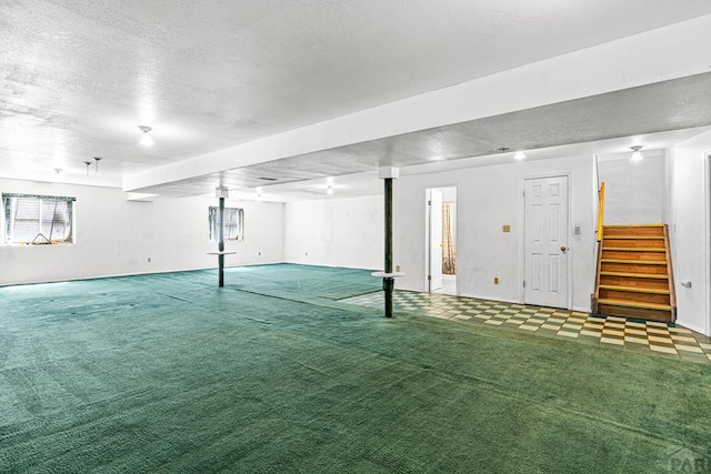 600 Hewitt St, Pueblo, CO 81005 - below grade area with stairway, a textured ceiling, and carpet flooring