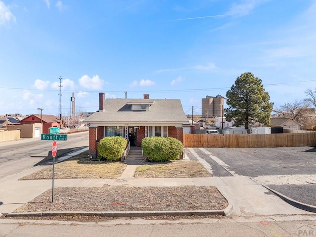 bungalow-style house with brick siding and fence