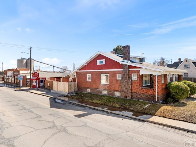 exterior space with brick siding and a chimney