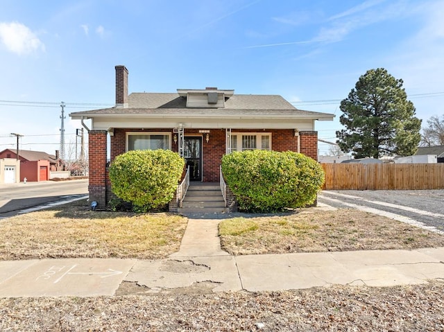 bungalow-style house with brick siding and fence