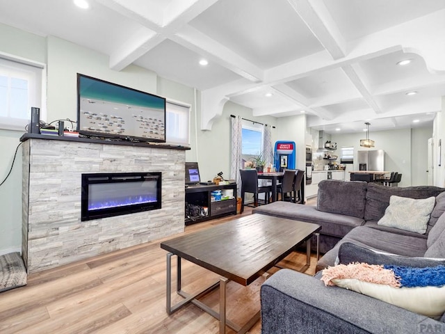 living area featuring coffered ceiling, wood finished floors, a stone fireplace, beam ceiling, and recessed lighting