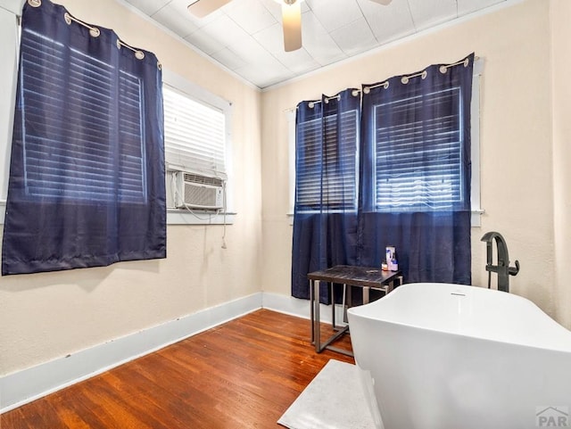 bedroom featuring baseboards, cooling unit, ceiling fan, and wood finished floors