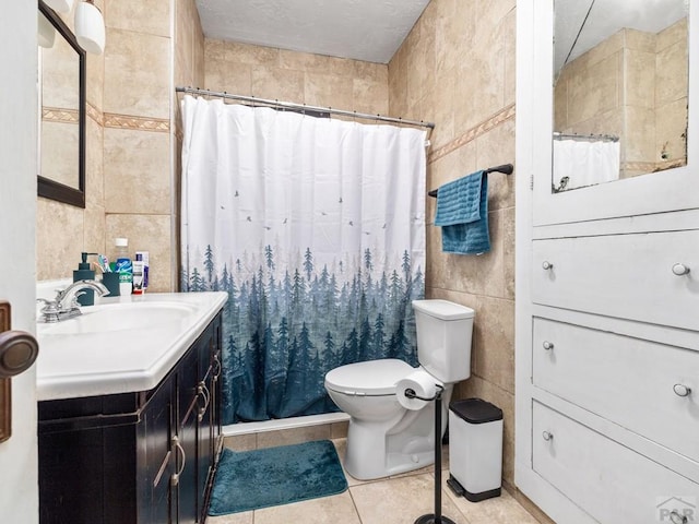 bathroom featuring toilet, tile walls, vanity, and tile patterned floors