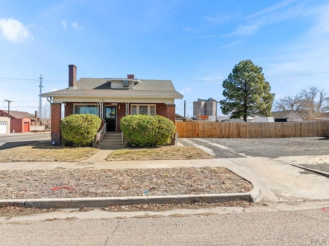 bungalow with brick siding and fence