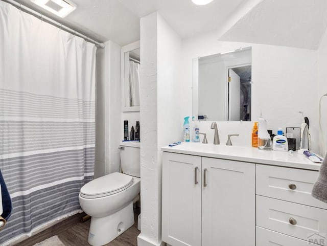 bathroom featuring visible vents, vanity, wood finished floors, and toilet