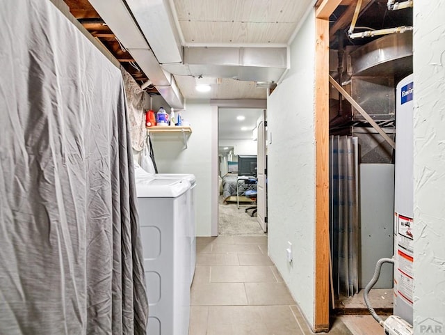 interior space featuring laundry area, tile patterned flooring, gas water heater, and washer and dryer