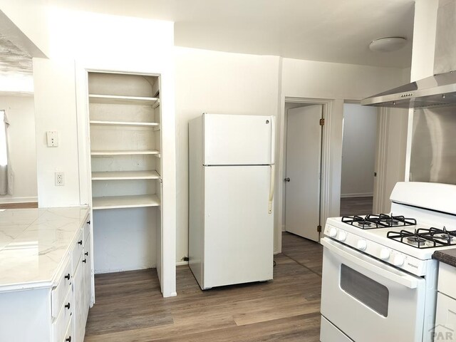 1143 25th Ln, Pueblo, CO 81006 - kitchen featuring white appliances, extractor fan, white cabinetry, light wood-style flooring, and light countertops