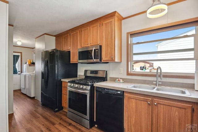 kitchen with black appliances, washer and dryer, light countertops, and a sink