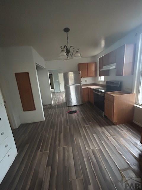 1045 Berkley Ave, Pueblo, CO 81004 - kitchen with freestanding refrigerator, electric range oven, under cabinet range hood, and dark wood-type flooring