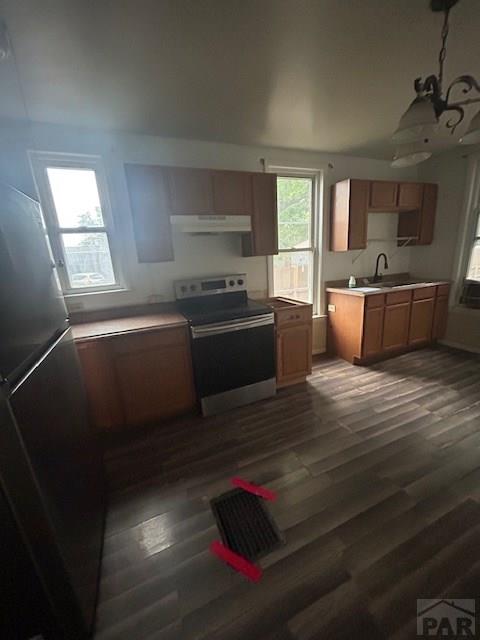 1045 Berkley Ave, Pueblo, CO 81004 - kitchen with stainless steel electric range oven, under cabinet range hood, dark wood-style floors, and light countertops