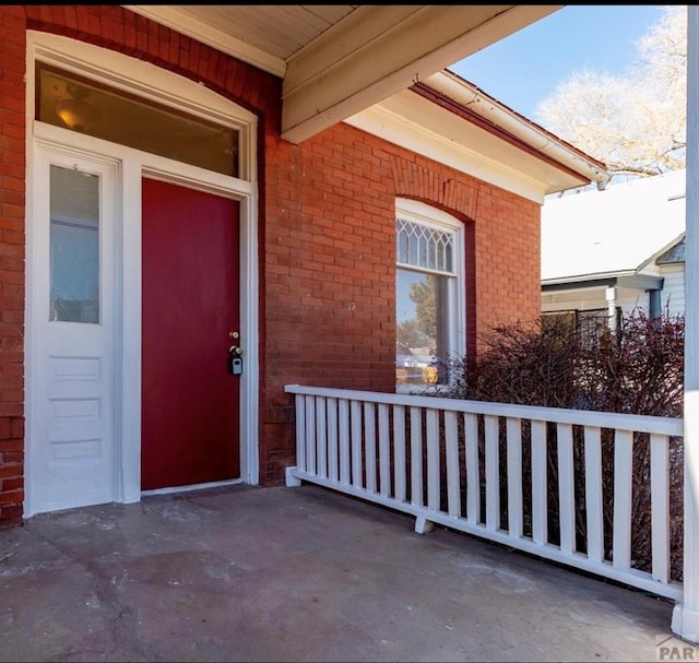 view of exterior entry featuring brick siding